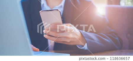 Close up,Businesswoman using mobile smart phone, working on laptop computer at office.For web banner. Close up,Businesswoman using mobile smart phone, working on laptop computer at office.For web banner. 118636657
