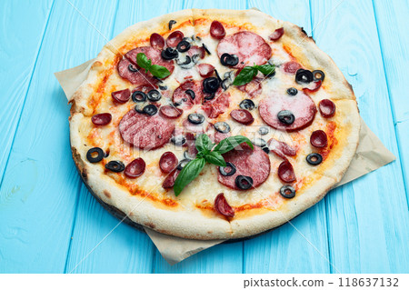 Pizza with mozzarella cheese , salami sausages , olives , and basil 118637132
