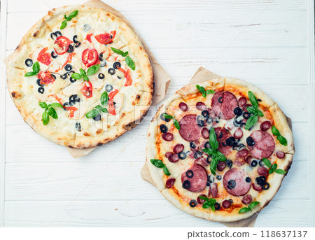 2 pizza with mozzarella cheese , salami sausages , olives , chicken , pineapple and tomatoes 118637137