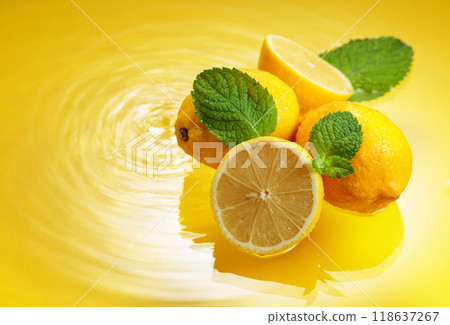 Juicy lemons with mint on a yellow background with water splashes. Juicy lemons with mint on a yellow background with water splashes. 118637267