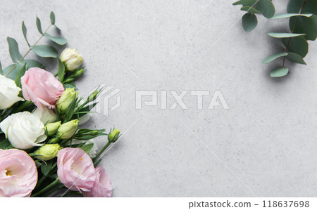 Delicate arrangement of mixed  flowers and eucalyptus leaves on a light grey surface 118637698