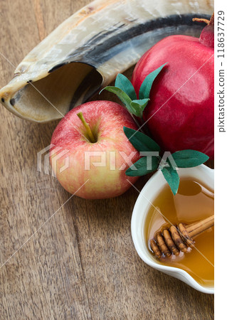 Rosh Hashanah Celebration Items. Pomegranate, apple, honey and shofar on wooden surface symbolizing Jewish New Year. 118637729