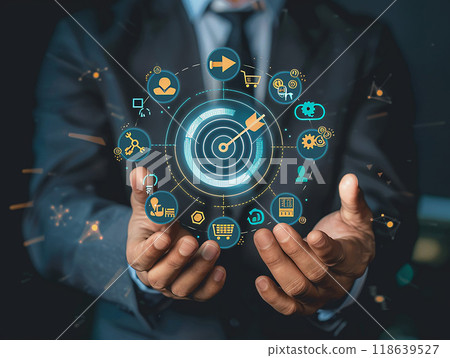 High resolution shot of a businessman showing a target board and marketing icons, with an arrow symbolizing a business action plan, 118639527