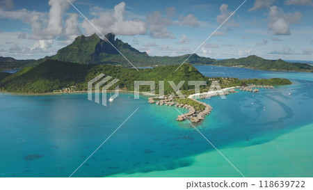 Topical island in French Polynesia with luxurious overwater bungalows resort and yacht sailing in turquoise lagoon. Bora Bora remote wild nature paradise, exotic summer luxury travel. Aerial view Topical island in French Polynesia with luxurious overwater bungalows resort and yacht sailing in turquoise lagoon. Bora Bora remote wild nature paradise, exotic summer luxury travel. Aerial view 118639722
