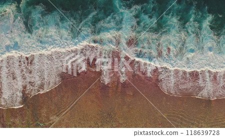 Aerial view turquoise green ocean waves crashing on beautiful pink orange sand beach. Scenery beauty of wild nature. Dark water foam waves break wash coastline. Tropic nobody nature seascape. Top down 118639728