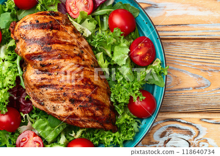 Grilled chicken breast ( fillet ) with lattuce salad and cherry tomatoes . Top view Grilled chicken breast ( fillet ) with lattuce salad and cherry tomatoes . Top view 118640734