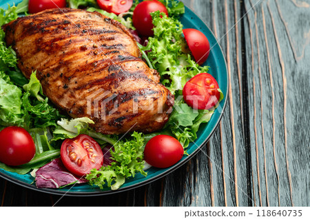 Grilled chicken breast ( fillet ) with lattuce salad and cherry tomatoes . Top view 118640735