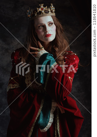 medieval queen in red dress with white makeup and crown 118641810