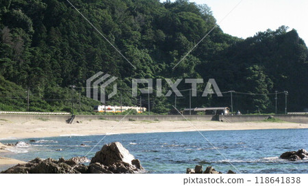 The Inaho Express train runs along the scenic Sasagawa Nagare coastline, the Sea of Japan and white sand with a clear blue sky. The Inaho Express train runs along the scenic Sasagawa Nagare coastline, the Sea of Japan and white sand with a clear blue sky. 118641838