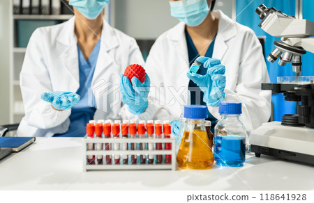 Chemist scientist holding test tube and tablet conducting experiment in laboratory with equipment, science concept. Chemist scientist holding test tube and tablet conducting experiment in laboratory with equipment, science concept. 118641928