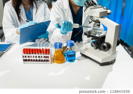 Chemist scientist holding test tube and tablet conducting experiment in laboratory with equipment, science concept. Chemist scientist holding test tube and tablet conducting experiment in laboratory with equipment, science concept. 118641930