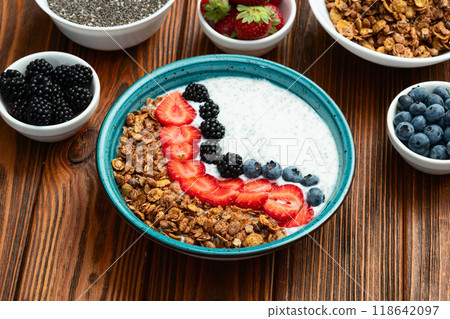 Healthy breakfast . Yogurt with berries ( strawberry , raspberry , blueberry , blackberry ) , granola and chia seeds . Top view 118642097