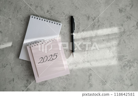 Top view of 2025 calendar, notepad and pen Top view of 2025 calendar, notepad and pen 118642581