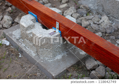 Wooden beam secured with metal bracket on concrete block Wooden beam secured with metal bracket on concrete block 118642749