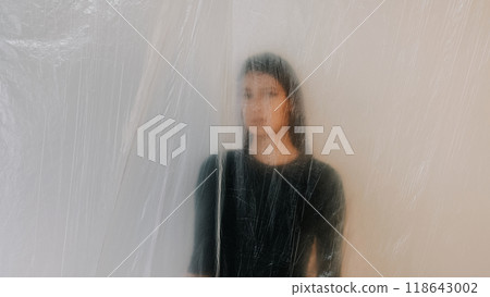 Woman aesthetic with soft blurred effect behind translucent plastic sheet showcasing artistic vision. 118643002
