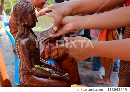 During Songkran, people engage in a traditional ritual of pouring water on Buddha statues as a mark of respect. 2 During Songkran, people engage in a traditional ritual of pouring water on Buddha statues as a mark of respect. 2 118643229