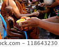 During Songkran, people engage in a traditional ritual of pouring water on Buddha statues as a mark of respect. 4 118643230