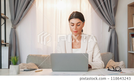 Office manager. Working woman. Digital project. Inspired elegant lady typing laptop sitting desk in light office room interior. 118643243