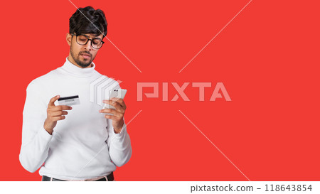 Bank scam. Online fraud. Electronic payment security. Concerned worried man using credit card phone mobile app isolated on red empty space background. 118643854