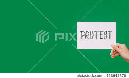 Protest sign. Strike placard. Social movement. Female hand showing rebellion lettering text isolated on green empty space background. Protest sign. Strike placard. Social movement. Female hand showing rebellion lettering text isolated on green empty space background. 118643876