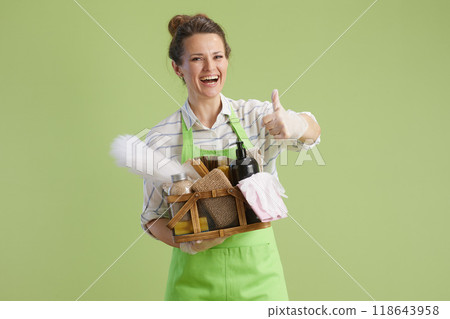happy modern housewife showing thumbs up isolated on green 118643958