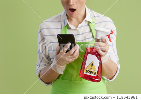 Shocked female using smartphone isolated on green Shocked female using smartphone isolated on green 118643961