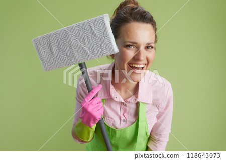 happy woman in green apron and rubber gloves isolated on green 118643973