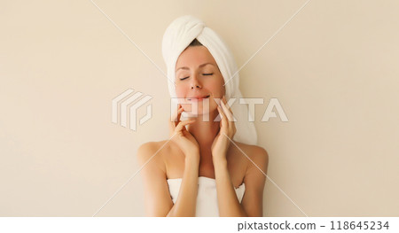 Beauty portrait of happy smiling young caucasian woman touches her clean skin while drying wet hair 118645234