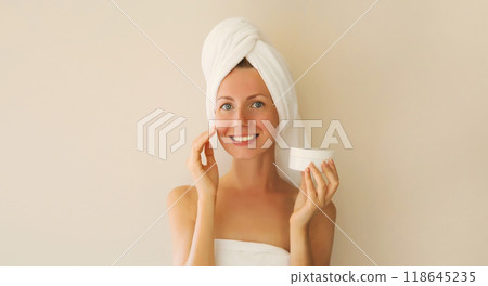 Beauty portrait of happy smiling young caucasian woman touches her clean skin applying face cream 118645235