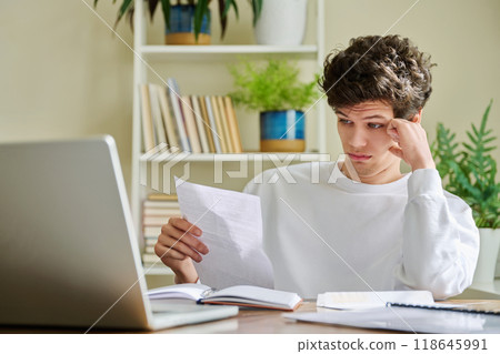 Serious young guy reading letter, paper document Serious young guy reading letter, paper document 118645991