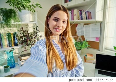 Selfie portrait of teenage cheerful female looking at web camera 118646072