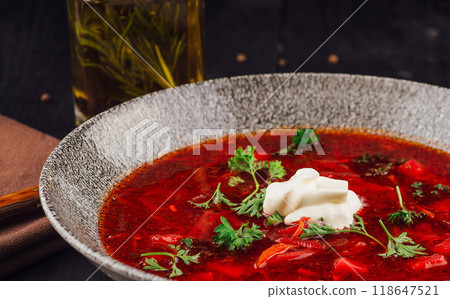 Steaming hot bowl of borscht with sour cream and parsley 118647521