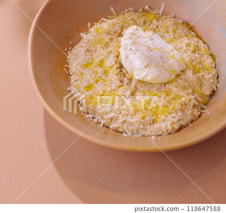 Creamy risotto with poached egg on pastel background 118647588