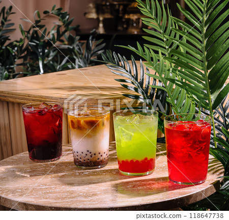 Four colorful summer cocktails resting on a stone tabletop in a tropical setting Four colorful summer cocktails resting on a stone tabletop in a tropical setting 118647738