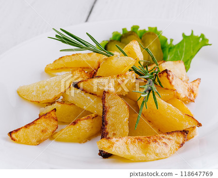 Delicious fried potatoes with rosemary lying on white plate 118647769