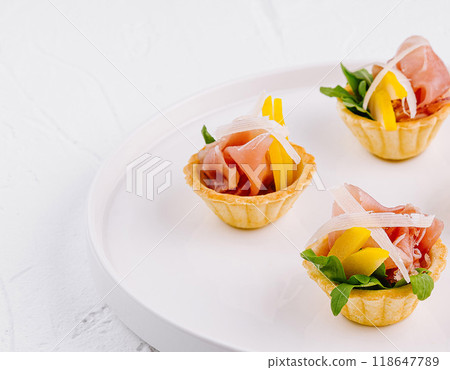 Gourmet prosciutto and melon canapes on white plate Gourmet prosciutto and melon canapes on white plate 118647789