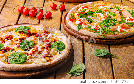 Gourmet italian pizzas on rustic wooden table Gourmet italian pizzas on rustic wooden table 118647791