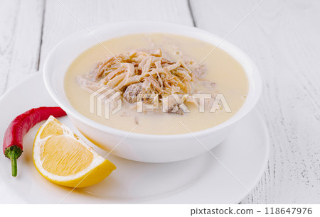 Turkish tripe soup is served on a white wooden table with lemon and pepper Turkish tripe soup is served on a white wooden table with lemon and pepper 118647976