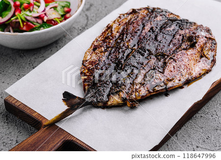 Grilled fish with fresh salad on rustic table 118647996