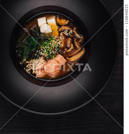 Steaming miso soup with salmon and shiitake mushrooms in black bowl 118648015