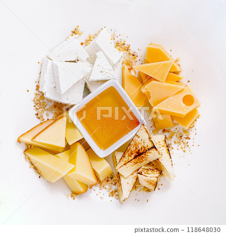 Different types of cheese arranged on plate with honey serving idea Different types of cheese arranged on plate with honey serving idea 118648030