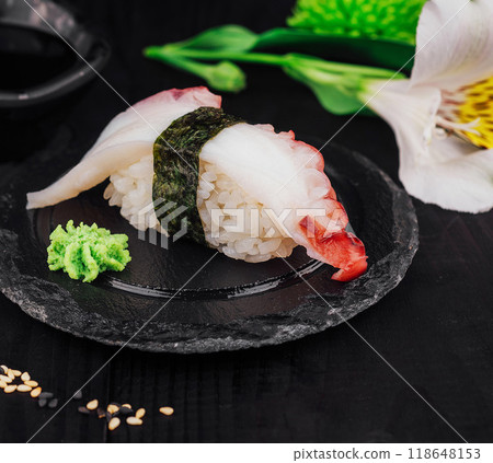 Delicious octopus sushi with wasabi resting on a black slate plate 118648153