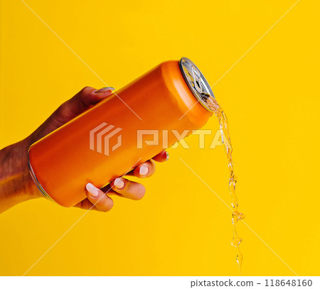 Woman holding spilling orange aluminum can on yellow background 118648160