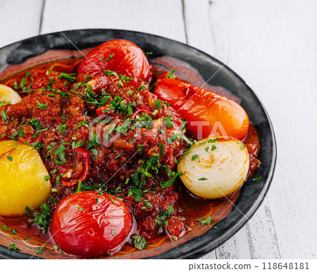 Spicy beef stew garnished with fresh herbs and vegetables on rustic plate Spicy beef stew garnished with fresh herbs and vegetables on rustic plate 118648181