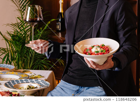 Man holding wine glass and fresh salad bowl 118648206
