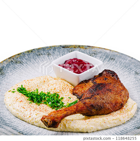 Roasted duck leg served on a plate with mashed potatoes and berry sauce Roasted duck leg served on a plate with mashed potatoes and berry sauce 118648255