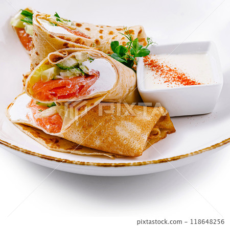 Pancakes with salmon and cream cheese filling on white plate Pancakes with salmon and cream cheese filling on white plate 118648256