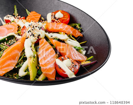 Delicious salad with salmon, avocado and cherry tomatoes being served on black plate 118648394