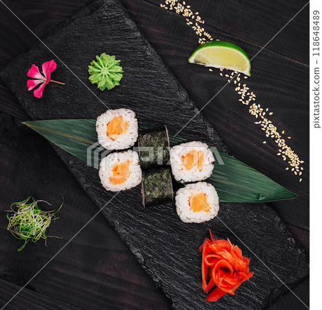 Salmon sushi rolls set served on black stone plate 118648489
