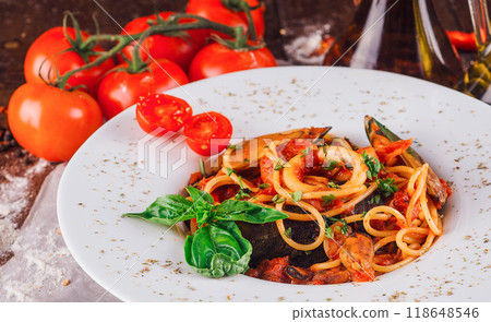 Delicious seafood pasta dish with mussels and squid being served on restaurant table Delicious seafood pasta dish with mussels and squid being served on restaurant table 118648546
